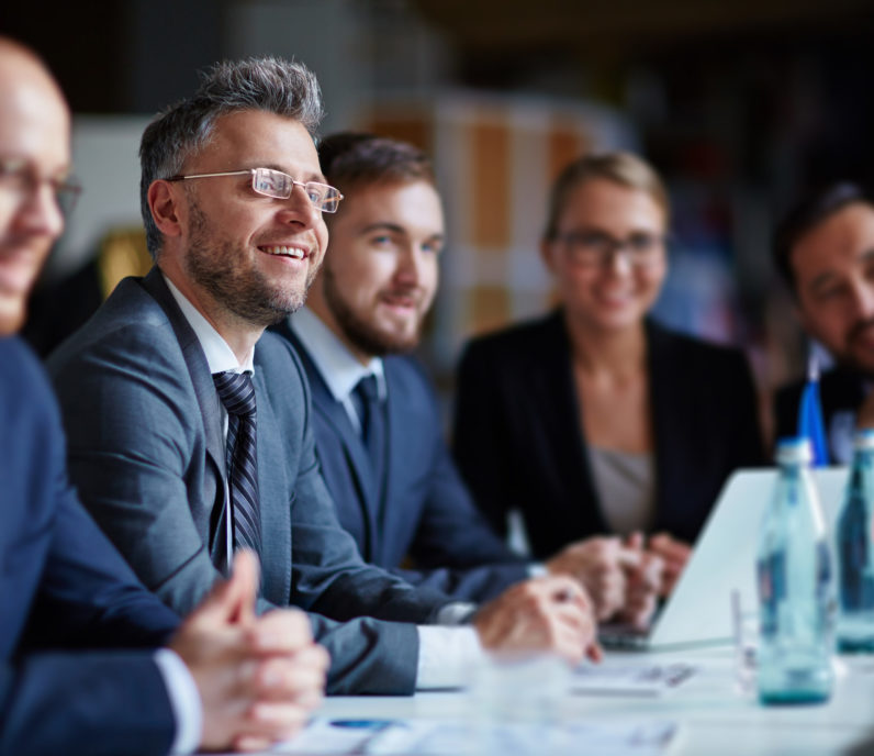 Successful businesspeople sitting at conference or seminar during lecture